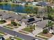 Aerial perspective showcasing homes near a lake with green lawns, and neighborhood street at 5105 Gato Del Sol Cir, Wesley Chapel, FL 33544