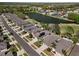 Aerial view of a neighborhood featuring well-kept houses alongside a peaceful lake surrounded by trees at 5105 Gato Del Sol Cir, Wesley Chapel, FL 33544