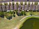 Overhead view showcasing homes with manicured lawns adjacent to a serene lake and walking path at 5105 Gato Del Sol Cir, Wesley Chapel, FL 33544