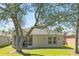Exterior view featuring a backyard with green grass and trees, showcasing the outdoor space at 5105 Gato Del Sol Cir, Wesley Chapel, FL 33544