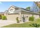 Exterior shot of a single-story house featuring an attached garage, well-kept lawn, and minimalist landscaping at 5105 Gato Del Sol Cir, Wesley Chapel, FL 33544