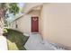 Inviting front entrance with a concrete walkway, minimalist landscaping, and a red entry door at 5105 Gato Del Sol Cir, Wesley Chapel, FL 33544