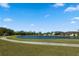 Scenic view of a tranquil lake surrounded by well-maintained lawns and homes under a clear blue sky at 5105 Gato Del Sol Cir, Wesley Chapel, FL 33544