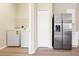 View of the laundry room and stainless steel refrigerator, with washer and dryer hookups for convenience at 5105 Gato Del Sol Cir, Wesley Chapel, FL 33544
