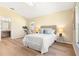 Bright primary bedroom featuring wood-look floors, a light color palette, and ensuite bathroom at 5105 Gato Del Sol Cir, Wesley Chapel, FL 33544