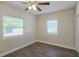 This bright bedroom features wood-look floors, a ceiling fan, and two windows with blinds at 515 34Th Ne Ave, St Petersburg, FL 33704