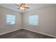 This bright bedroom features wood-look floors, a ceiling fan, and two windows with blinds at 515 34Th Ne Ave, St Petersburg, FL 33704