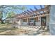 Inviting front porch featuring a pergola, stone accents, seating, and a stylish front door with glass inserts at 515 34Th Ne Ave, St Petersburg, FL 33704