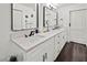 Modern bathroom features a dual sink vanity with stone countertop, black fixtures, plank floors, and stylish mirrors at 523 Bayport Way # 523, Longboat Key, FL 34228