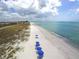 A beautiful beach with blue lounge chairs and umbrellas, perfect for relaxing at 523 Bayport Way # 523, Longboat Key, FL 34228