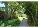 Tranquil garden path with lush foliage and mature trees in a well-maintained community at 523 Bayport Way # 523, Longboat Key, FL 34228