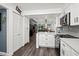 Well lit kitchen features white cabinetry, stainless steel appliances, and an adjacent view into the living area at 523 Bayport Way # 523, Longboat Key, FL 34228