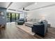 Bright living room featuring beamed ceiling, comfortable seating, wood floors, and sliding glass doors to the outside patio at 523 Bayport Way # 523, Longboat Key, FL 34228