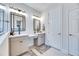 Bathroom with gray double vanity, modern black framed mirrors and lights, and tiled shower at 5402 Limelight Dr, Apollo Beach, FL 33572