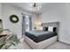Bedroom with gray upholstered bed, neutral walls, and modern light fixture and furnishings at 5402 Limelight Dr, Apollo Beach, FL 33572