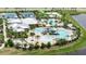 Aerial view of a community pool and clubhouse with a pool slide, splash pad, and tennis and volleyball courts at 5402 Limelight Dr, Apollo Beach, FL 33572