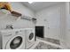 A well-equipped laundry room with modern washer and dryer, storage shelves, and a stylish rug at 5402 Limelight Dr, Apollo Beach, FL 33572