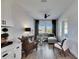 Bright living room with wood-look tile, modern furniture, fan, and backyard views through large windows at 5402 Limelight Dr, Apollo Beach, FL 33572