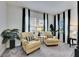 Sitting area in main bedroom with neutral chairs, black and white accents, and bright window lighting at 5402 Limelight Dr, Apollo Beach, FL 33572