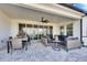 Relaxing covered patio with stylish outdoor furniture, ceiling fan, and sliding glass doors into the home's interior at 5402 Limelight Dr, Apollo Beach, FL 33572