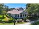 Exterior view of home showcasing landscaping, white columns, and trimmed hedges at 6002 Churchside Dr, Lithia, FL 33547