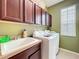 Functional laundry room with a utility sink, washer, dryer, and ample cabinet space at 6002 Churchside Dr, Lithia, FL 33547