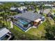 Aerial view of home showing pool, lanai, outdoor kitchen, lush landscaping and boat dock at 6614 Blackfin Way, Apollo Beach, FL 33572