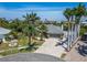 Stunning aerial view of a coastal home with lush landscaping, palm trees, and a paver driveway at 6614 Blackfin Way, Apollo Beach, FL 33572