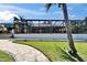 Beautiful backyard featuring lush green lawn, screened-in patio, and mature palm trees at 6614 Blackfin Way, Apollo Beach, FL 33572