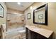 Bathroom with a bathtub and shower with tile surround and vanity with tan marble countertop at 6614 Blackfin Way, Apollo Beach, FL 33572