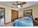 Comfortable bedroom with wood furnishings, a ceiling fan, and a large window with blinds at 6614 Blackfin Way, Apollo Beach, FL 33572