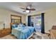 Cozy bedroom with a ceiling fan, outdoor access, and coordinated blue bedding at 6614 Blackfin Way, Apollo Beach, FL 33572