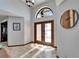 Foyer with tiled floor, a front door with sidelights, transom window, chandelier, and wall clock at 6614 Blackfin Way, Apollo Beach, FL 33572