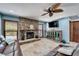 Comfortable living room has stone fireplace, decorative ceiling fan, and cabinet at 6614 Blackfin Way, Apollo Beach, FL 33572