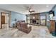 Spacious living room with a stone fireplace, tile floors, and comfortable leather furniture at 6614 Blackfin Way, Apollo Beach, FL 33572