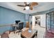 A comfortable office with a ceiling fan, desk, chair, and French doors at 6614 Blackfin Way, Apollo Beach, FL 33572