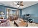Office with travertine tile, blue walls, ceiling fan, shutters, wet bar, sofa, and desk at 6614 Blackfin Way, Apollo Beach, FL 33572