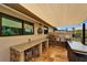 Covered outdoor kitchen featuring a granite countertop, stainless steel sink, and ample workspace at 6614 Blackfin Way, Apollo Beach, FL 33572