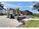 Inviting outdoor patio with brick pavers, palm trees, and a screened-in lanai at 6614 Blackfin Way, Apollo Beach, FL 33572