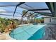 Screened-in pool area with lush landscaping, underwater rock feature, and clear water at 6614 Blackfin Way, Apollo Beach, FL 33572
