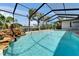 Clear swimming pool in a screened-in lanai, surrounded by tropical landscaping at 6614 Blackfin Way, Apollo Beach, FL 33572