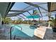 Sparkling pool with a rock waterfall feature and tropical landscaping in an enclosed lanai at 6614 Blackfin Way, Apollo Beach, FL 33572