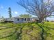 Spacious backyard featuring lush green grass, mature trees, and serene waterfront views at 7160 S Shore S Dr, South Pasadena, FL 33707