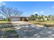 Charming single-story home featuring a two-car garage and beautiful landscaping, complemented by the clear blue sky at 7160 S Shore S Dr, South Pasadena, FL 33707