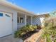 Inviting front entrance with a tiled walkway, mature landscaping, and a cozy porch at 7160 S Shore S Dr, South Pasadena, FL 33707