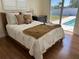Cozy bedroom with pool view, featuring a plush bed, light shutters, and modern decor at 731 Snug Is, Clearwater, FL 33767