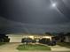 Night view of home featuring a two-car garage and mature landscaping at 731 Snug Is, Clearwater, FL 33767