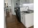 A stylish laundry room equipped with granite countertops, stainless steel sink and modern appliances at 731 Snug Is, Clearwater, FL 33767