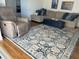 Living room showcasing a recliner, patterned rug, sectional sofa with blue pillows and ottoman at 731 Snug Is, Clearwater, FL 33767