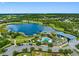 Expansive community view featuring a large lake, community pool, clubhouse, and surrounding lush greenery at 7415 Paradiso Dr, Apollo Beach, FL 33572